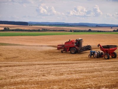 Colheitadeira e trator trabalhando em lavoura durante a colheita em Entre Rios, Brasil.